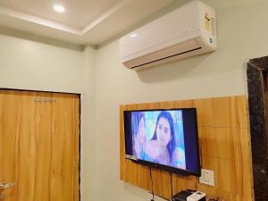 a flat screen tv on a wall in a room at Hotel Guru Kripa - 500mtr from shreenathji temple in Nāthdwāra