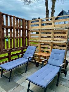 2 stoelen en een bank op een patio bij Gleis 2, Waggon mit Ofen, Whirlpool und Sauna in Dahlem