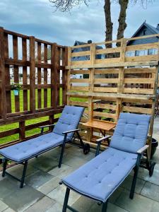 two chairs and a bench on a patio at Gleis 2, Waggon mit Ofen, optional mit Whirlpool und Sauna in Dahlem