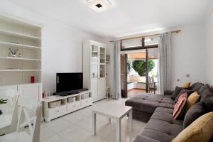 a living room with a couch and a tv at Casa Carmen in Puerto del Carmen