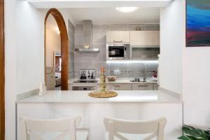a kitchen with white cabinets and a table and chairs at Casa Carmen in Puerto del Carmen +13 photos