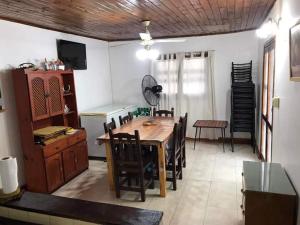 a dining room with a wooden table and chairs at Alojamiento La Mamu 1 in Paso de la Patria