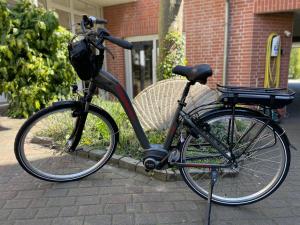 ein Fahrrad steht vor einem Gebäude geparkt in der Unterkunft Hotel-Restaurant Zur Mühle in Schermbeck