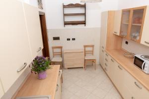 eine Küche mit einer Theke und 2 Stühlen darin in der Unterkunft Living Sestri Airport in Genua