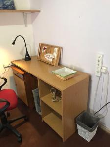 un escritorio con una lámpara y una foto en él en Habitacion Super Comoda en Casa Particular en Tandil
