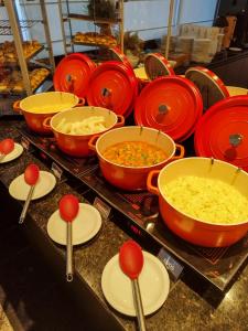 un buffet lleno de tazones de comida y cucharas en Hotel Reymar Express, en Maceió