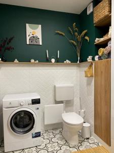 a bathroom with a washing machine and a toilet at Újhely vára Apartman in Sátoraljaújhely