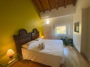 een slaapkamer met een bed met witte lakens en een raam bij Villa Dragoni in Buttrio