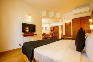 Una habitación de hotel con una cama y un televisor de pantalla plana. en Evoma, en Bangalore