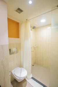 un baño con inodoro y ducha en Evoma, en Bangalore
