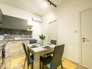 comedor con mesa y sillas en la cocina en Stylish one bedroom apartment in Gzira 1 en Il-Gżira