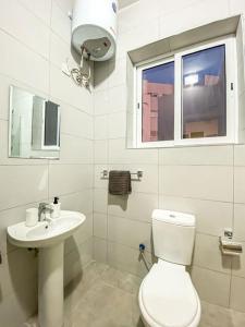 baño con aseo y lavabo y ventana en Stylish one bedroom apartment in Gzira 1 en Il-Gżira