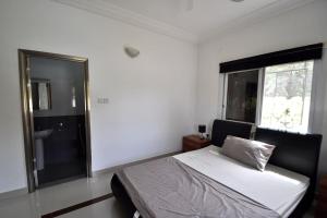 a bedroom with a bed and a shower and a window at Rosa Parks Villa - Sanyang The Gambia in How Ba