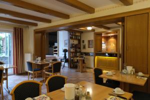 a restaurant with tables and chairs and a kitchen at Hotel-Restaurant Zur Mühle in Schermbeck
