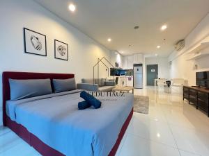 - une chambre avec un lit avec un animal farci bleu dans l'établissement Mercu Summer Suites, à Kuala Lumpur