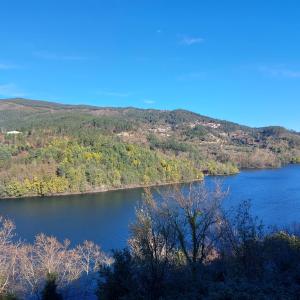 a view of a lake with trees and mountains at Casa do Penedo - Quinta de Fundevilla in Geres