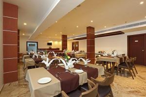 Eloor Tourist Home في إرناكولام: مطعم فيه طاولات وكراسي في الغرفة