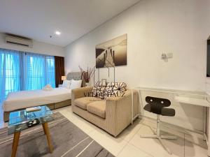 - un salon avec un lit et un canapé dans l'établissement Mercu Summer Suites, à Kuala Lumpur