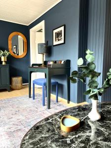 ein Wohnzimmer mit einem Schreibtisch und einer blauen Wand in der Unterkunft "Ohuus" Ferienhaus mit Garten in Büsum