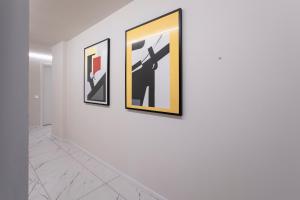 a group of framed art on a wall in a hallway at Ah Villaglori Boutique Apartments in Brescia