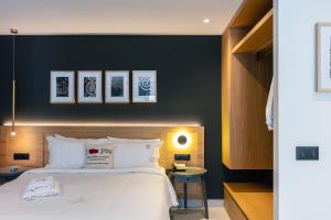 a bedroom with a large bed with a black wall at Porta Suites in Heraklio Town