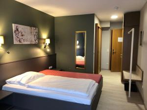 a bedroom with a bed and a mirror at Hotel-Restaurant Zur Mühle in Schermbeck