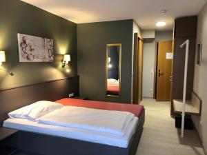 Schlafzimmer mit einem Bett und einem Spiegel in der Unterkunft Hotel-Restaurant Zur Mühle in Schermbeck