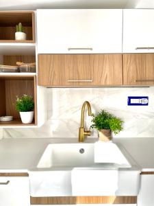 a white kitchen with a sink and wooden cabinets at Residenza AquaLaguna in Tropea