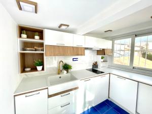 a kitchen with white cabinets and a blue floor at Luxury in the heart of Tropea- Residenza AquaLaguna in Tropea