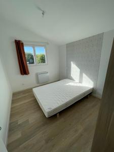 een witte kamer met een groot bed. bij La grange in Saint-Laurent-sur-Sèvre