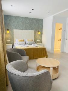 a bedroom with a bed with chairs and a table at Hostal Alisol Boutique San Pedro in Marbella