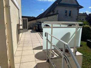 a white house with a staircase in a yard at Jolie maison de ville avec terrasse et jardin in Warcq