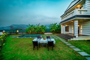 a table in the yard of a house at Spicy Mango Villa Insam - Hill View Villa In Karjat in Karjat