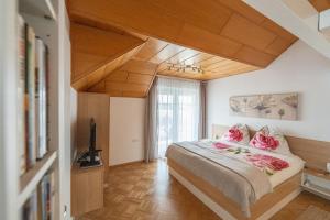 Schlafzimmer mit einem Bett mit rosa Kissen und einem TV in der Unterkunft Ferienhaus Karoline in Lichtpold