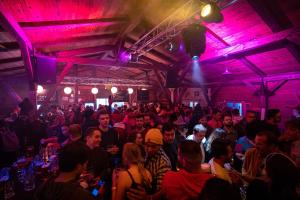 a crowd of people in a room with purple lights at Wies'n Camp in Munich +15 photos