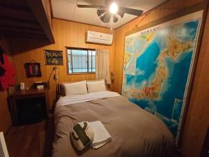 łóżko w pokoju z mapą na ścianie w obiekcie 88 House Hiroshima w mieście Hiroszima