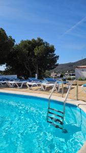 a swimming pool with a chair in the water at Hotel S´Aguarda in Cadaqués