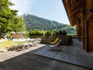 a deck with a table and chairs on a house at Appartement La Clusaz, 4 pièces, 7 personnes - FR-1-304-232 in La Clusaz