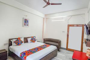 a bedroom with a bed and a ceiling fan at FabHotel New Shanti in Allahābād +30 photos