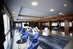 a waiting room with blue chairs and tables in a building at Lara Otel in Antalya