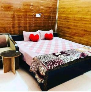 a bedroom with a bed with two red pillows at OYO Mayur Guest House in Jīnd