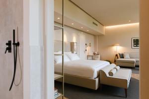 una camera da letto con un grande letto bianco e uno specchio di Palazzo BelVedere a Montecatini Terme