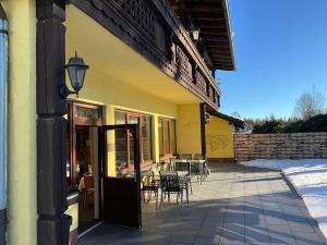 a building with a patio with tables and chairs at Hotel Schachten in Lindberg