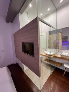 bagno con parete in vetro, TV e lavandino di Apartment Feel Good a Zagabria