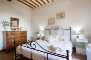 una camera da letto con un letto con lenzuola bianche e un comò di Guest House il Gatto a Gaiole in Chianti