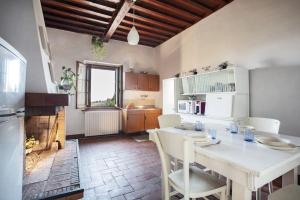Guest House il Gatto في غايولي إن كيانتي: مطبخ مع طاولة وكراسي ومدفأة