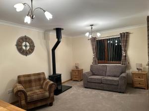 a living room with two chairs and a stove at Deleted in Airdrie