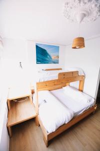 a bedroom with two bunk beds and a desk at Latas Surf House in Somo