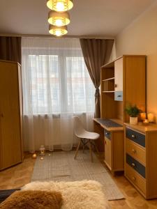 1 dormitorio con escritorio, silla y ventana en Baśniowy Apartament, en Lublin