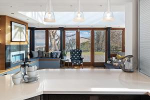 cocina con encimeras blancas y sala de estar. en Oaktree Lodge - Luxury Cottage, Hot Tub, Sea Views, en Saundersfoot
